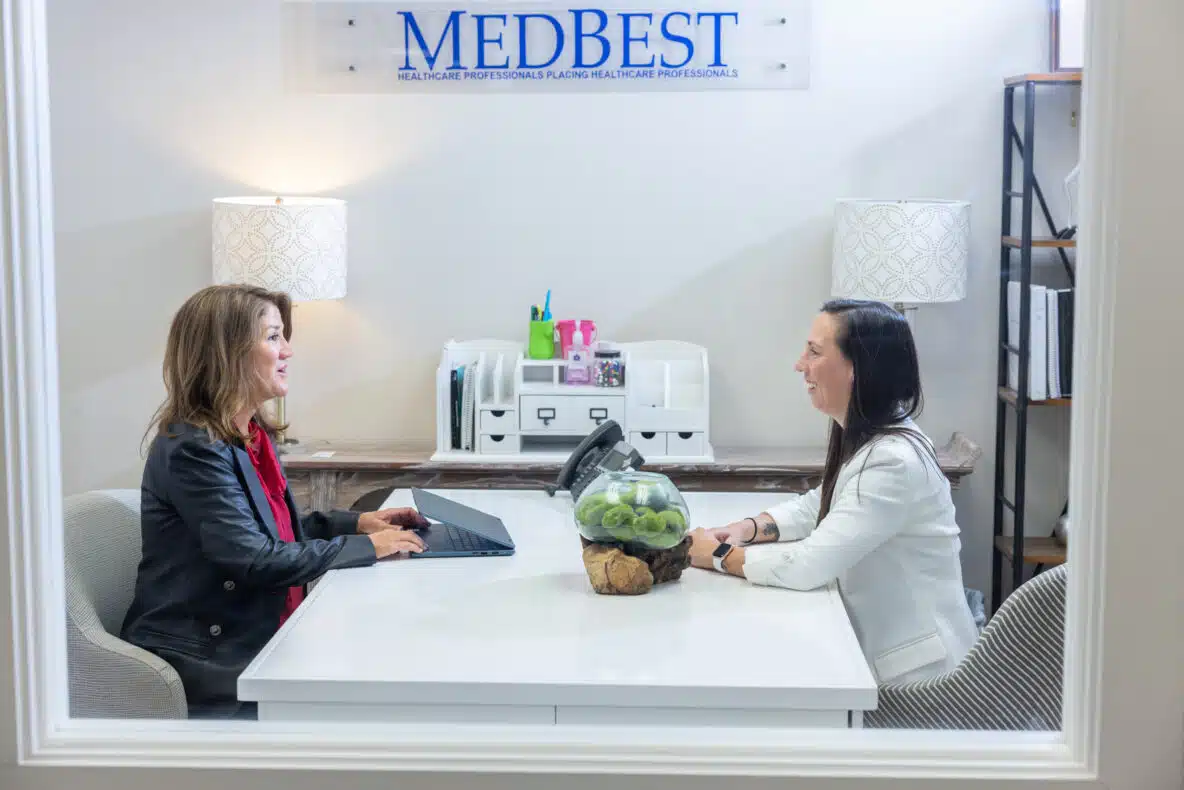 Two women sitting across a desk discussing hiring Executive Director
