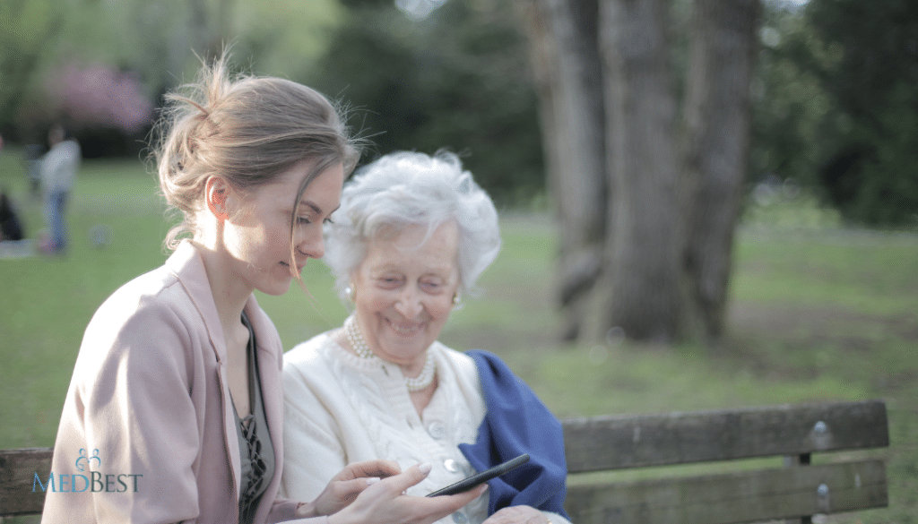 Interim Memory Care Director sits with Female Dementia resident in outside setting