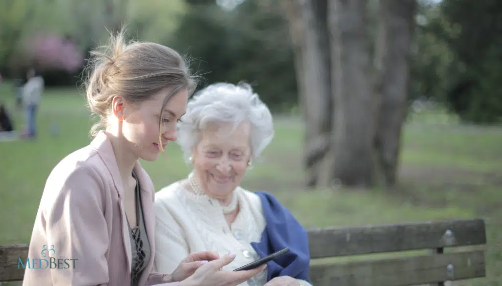 Interim Memory Care Director sits with Female Dementia resident in outside setting