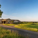 Rural skilled nursing facility surrounded by open farmland at sunset